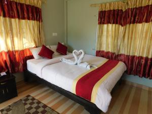 a bedroom with a large bed with towels on it at Harvest Moon Guest House in Pokhara