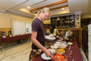 a woman is preparing food at a buffet at Pokhara Choice Inn in Pokhara