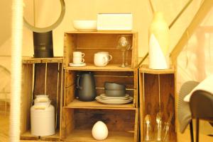 a wooden shelf with dishes and other items on it at Cosy Tents - Daylesford in Yandoit
