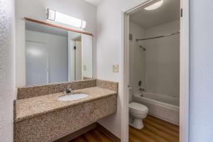 La salle de bains est pourvue d'un lavabo, de toilettes et d'un miroir. dans l'établissement Motel 6-Beaverton, OR, à Beaverton