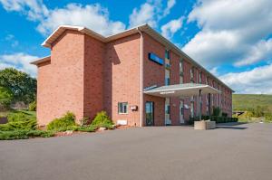 DrumsMotel 6-Drums的砖砌的建筑,前面设有停车场