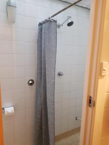 a shower with a gray shower curtain in a bathroom at Morphett Arms Hotel in Adelaide