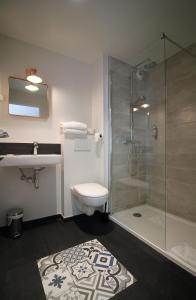 La salle de bains est pourvue d'une douche, de toilettes et d'un lavabo. dans l'établissement Hôtel La Fontaine Caen Centre, à Caen