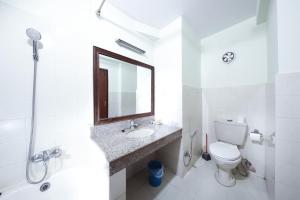 a bathroom with a toilet, sink, and mirror at Samsara Boutique Hotel in Kathmandu
