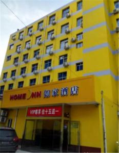 een geel gebouw met een opschrift erop bij Home Inn Yangquan Xinglong Street Walmart in Yangquan