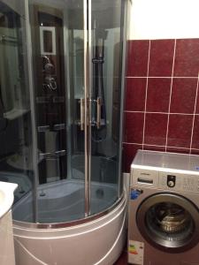 a shower in a bathroom with a washing machine at Apartment Ozernaya 7 in Tver