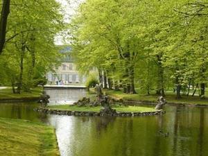 un parque con un estanque y árboles y un edificio en Meister BÄR HOTEL Bayreuth, en Goldkronach