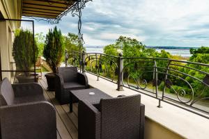 a balcony with chairs and tables and a view of the ocean at Milano Hotel in Burgas
