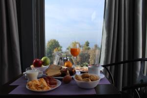 a breakfast table with food and drinks and a window at Galaxy Hotel in Athens