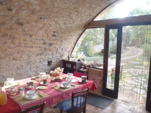 een eetkamer met een tafel en een groot raam bij chambres du Domaine de Bombes in Mostuéjouls