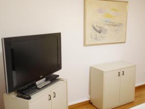 アテネにあるAreos Apartmentの白いキャビネットの上に座る薄型テレビ