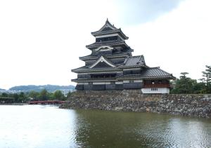 a large building next to a body of water at Hotel Trend Matsumoto in Matsumoto