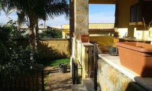 un balcón de una casa con una palmera en Girasole en Terrasini Favarotta