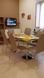 comedor con mesa, sillas y TV en Sorge Palace, en Mussomeli