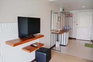 a living room with a flat screen tv on a wall at Assasa Huahin in Hua Hin
