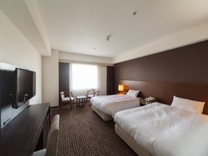 מיטה או מיטות בחדר ב-KKR Hotel Nagoya