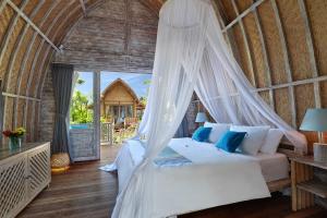 ein Schlafzimmer mit einem Himmelbett in der Unterkunft Uluwatu Lumbung Cottages in Uluwatu
