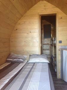 sypialnia z 2 łóżkami w drewnianym domku w obiekcie La Colline Aux Cabanes w mieście Espaly-Saint-Marcel