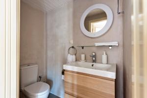 uma casa de banho com um lavatório, um WC e um espelho. em Corfu Town Stylish Apartment em Corfu Town