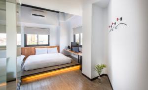 1 dormitorio con 1 cama y escritorio con ordenador en Traveller Inn TieHua Cultural and Creative Hotel, en Taitung