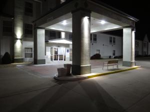 a bench sitting under a building at night at Windsor Inn & Suites in Dodge City