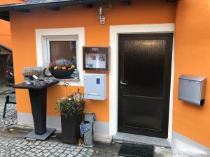 a building with an orange wall with a black door at Gasthof zum Waldstein in Zell im Fichtelgebirge