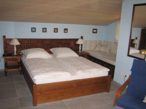 a bedroom with a large bed and a bench at Haus Osterried in Schwangau