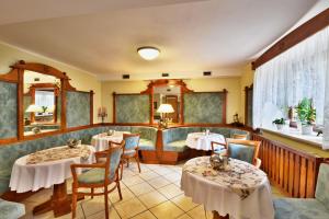 una sala da pranzo con due tavoli e sedie di Hotel Villa Conti a Písek