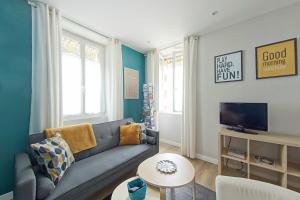 a living room with a couch and a tv at Les Salorges in Le Croisic