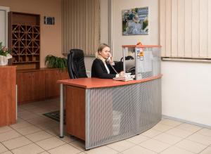 a woman sitting at a reception desk in a lobby at Lilleküla Hotel in Tallinn