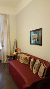 ein Wohnzimmer mit einer roten Couch mit Kissen darauf in der Unterkunft tagliaferri lucia in Rom