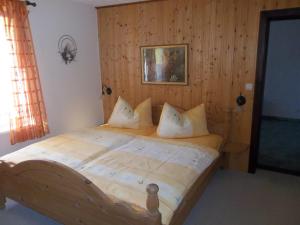 1 dormitorio con cama de madera y almohadas en Ferienwohnung Günschmann en Hausen