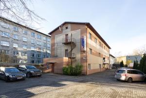 a building with cars parked in a parking lot at Lilleküla Hotel in Tallinn