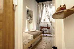 a small bedroom with a bed and a table at Palazzo Farnese Historical Home in Rome