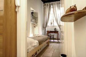 ローマにあるPalazzo Farnese Historical Homeの小さなベッドルーム(ベッド1台、テーブル付)