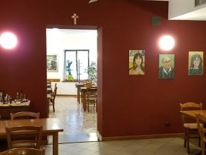 une salle à manger avec des tables et une croix sur le mur dans l'établissement I Personaggi, à Udine