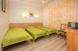 een hotelkamer met 2 bedden en een televisie bij Lilleküla Hotel in Tallinn