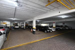 a parking garage with several cars parked in it at Hotel Malibu in São Carlos