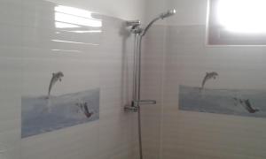 a shower with two shower heads in a bathroom at Hug Inn Beach Hotel in Hikkaduwa