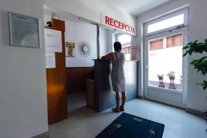 a woman standing at a reception counter in a restaurant at Pansion Kipovi in Tuzla