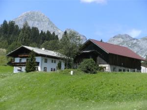dom na wzgórzu z górami w tle w obiekcie Oberharreithhof w mieście Sankt Martin am Tennengebirge