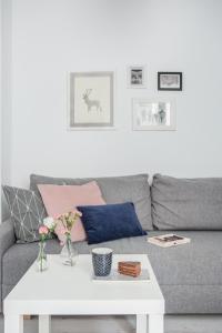 a living room with a gray couch with a white coffee table at Palm Aparts Warsaw in Warsaw