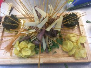 a wooden cutting board with vegetables and bamboo sticks at Agriturismo Montebeltrano in Paterno Calabro
