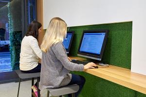 two women sitting at a desk with a computer at East Hostel in Jiaoxi