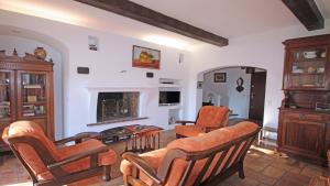 ein Wohnzimmer mit einem Sofa, Stühlen und einem Kamin in der Unterkunft Villa Cavok in Sainte-Maxime