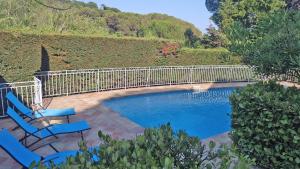 einen Pool mit zwei blauen Stühlen und einem Zaun in der Unterkunft Villa Cavok in Sainte-Maxime