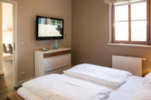 a bedroom with two beds and a flat screen tv at Autorenhaus Franz Kafka in Ahlbeck