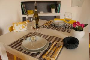 ローマにあるAppartamento Floridianaのテーブル(皿、グラス、ワイン1本付)
