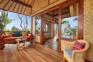 ein Wohnzimmer mit Sofa und Tisch in der Unterkunft Uluwatu Lumbung Cottages in Uluwatu