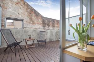 a balcony with a chair and a desk and a brick wall at Onix Liceo in Barcelona
